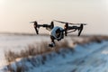 White drone with digital camera flying and landing on snow