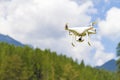 White drone flying above mountains. Royalty Free Stock Photo