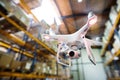 White drone flying inside the warehouse.