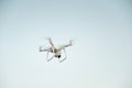 White drone hovering in a bright blue sky Royalty Free Stock Photo
