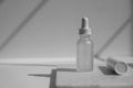 White dropper bottle on the marble. beauty cosmetic skincare packaging on natural light and shadow