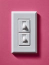 White dual light switch on pink wall background. Royalty Free Stock Photo