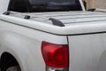 White dusty pickup truck in the parking lot.