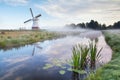 White Dutch windmill in misty morning Royalty Free Stock Photo