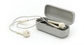 White earbud-style headphones wrapped and placed inside a rectangular, gray plastic Royalty Free Stock Photo