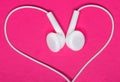 White earphone on pink background, heart Royalty Free Stock Photo