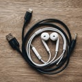 White earphones and charging cables arranged Royalty Free Stock Photo