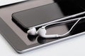 White earphones on tablet and phone Royalty Free Stock Photo