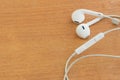 White earphones on wooden desk