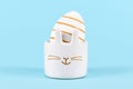 White Easter egg painted with golden stripes in cute bunny shaped egg cup Royalty Free Stock Photo