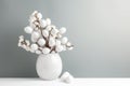 White Easter eggs arranged in a vase with blossoming branches on a gray background evoke a feeling of spring and renewal Royalty Free Stock Photo