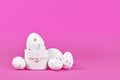 White Easter eggs with golden dots and, cute egg cup in shape of bunny on pink background Royalty Free Stock Photo