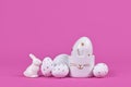 White easter eggs with golden dots, and egg cup in shape of bunny on pink background Royalty Free Stock Photo