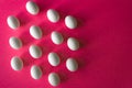 White Easter eggs in hexagon band on bright pink color background with copy space