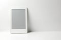 White ebook reader device sits on white surface. Blank screen displays grey. Modern tech gadget for reading books, digital Royalty Free Stock Photo