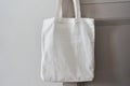 White eco friendly bag hanging on the door handle. Canvas tote bag