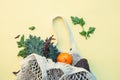 White eco-friendly textile string bag with fresh fruits, herbs and vegetables