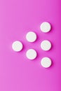 White Ecstasy pills in a row on a pink background, isolate. Royalty Free Stock Photo