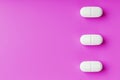 White Ecstasy pills in a row on a pink background, isolate. Royalty Free Stock Photo