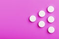 White Ecstasy pills in a row on a pink background, isolate Royalty Free Stock Photo