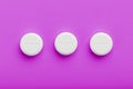 White Ecstasy pills in a row on a pink background, isolate. Royalty Free Stock Photo