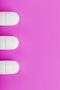 White Ecstasy pills in a row on a pink background, isolate. Royalty Free Stock Photo