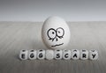 White egg with frightened face on white wooden background Royalty Free Stock Photo
