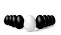 White egg in front of black eggs Royalty Free Stock Photo