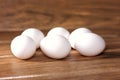 Six loose eggs on a wooden board