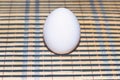 white egg on a striped wooden backing. Royalty Free Stock Photo