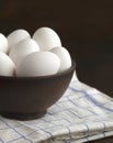 White eggs in a clay bowl on a wooden table. Royalty Free Stock Photo
