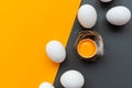 White eggs and egg yolk into nest on yellow and gray background. Top view. Flat lay. Easter celebration Royalty Free Stock Photo