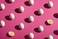 White eggs and half of peeled boiled egg pattern on pink purple colors plain minimal background Royalty Free Stock Photo