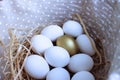 White eggs and one golden egg in the basket. Easter composition in a rustic style. Royalty Free Stock Photo