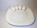 White eggs on a white plate on a white background. The birth of life. 4 Chicken eggs Royalty Free Stock Photo