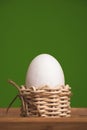 White eggs in small baskets and green background Royalty Free Stock Photo