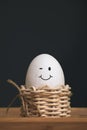 White eggs in small baskets with smiling icon and black background Royalty Free Stock Photo