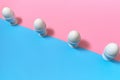 White eggs standing on egg cup on blue and pink pastel background, copy space. Row of boiled eggs in stand on paper background Royalty Free Stock Photo