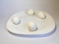 White eggs on a white plate on a white background. The birth of life. 4 Chicken eggs Royalty Free Stock Photo