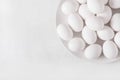 White eggs on a white plate on a white background. Eggs. Easter photo concept.