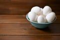 White eggs on wooden plate