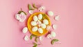 White Eggs on Yellow plate flowers On Pink Background Ester Holiday Background Concept