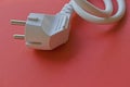 White electric euro plug on red background Royalty Free Stock Photo
