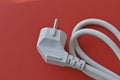 White electric euro plug on red background Royalty Free Stock Photo