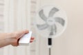 White electric fan turns on, turns off with the remote control. Hand hold electric fan remote Royalty Free Stock Photo