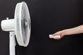 White electric fan turns on, turns off with the remote control. Hand hold electric fan remote Royalty Free Stock Photo