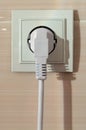 White electric power sockets on wall background with plugged electric plug Royalty Free Stock Photo