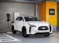 White electric SUV recharging in parking garage