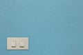 White electric switch on blue cement wall. Royalty Free Stock Photo