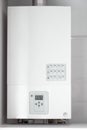 White electric water heater with electronic panel mounted in a kitchen cabinet Royalty Free Stock Photo